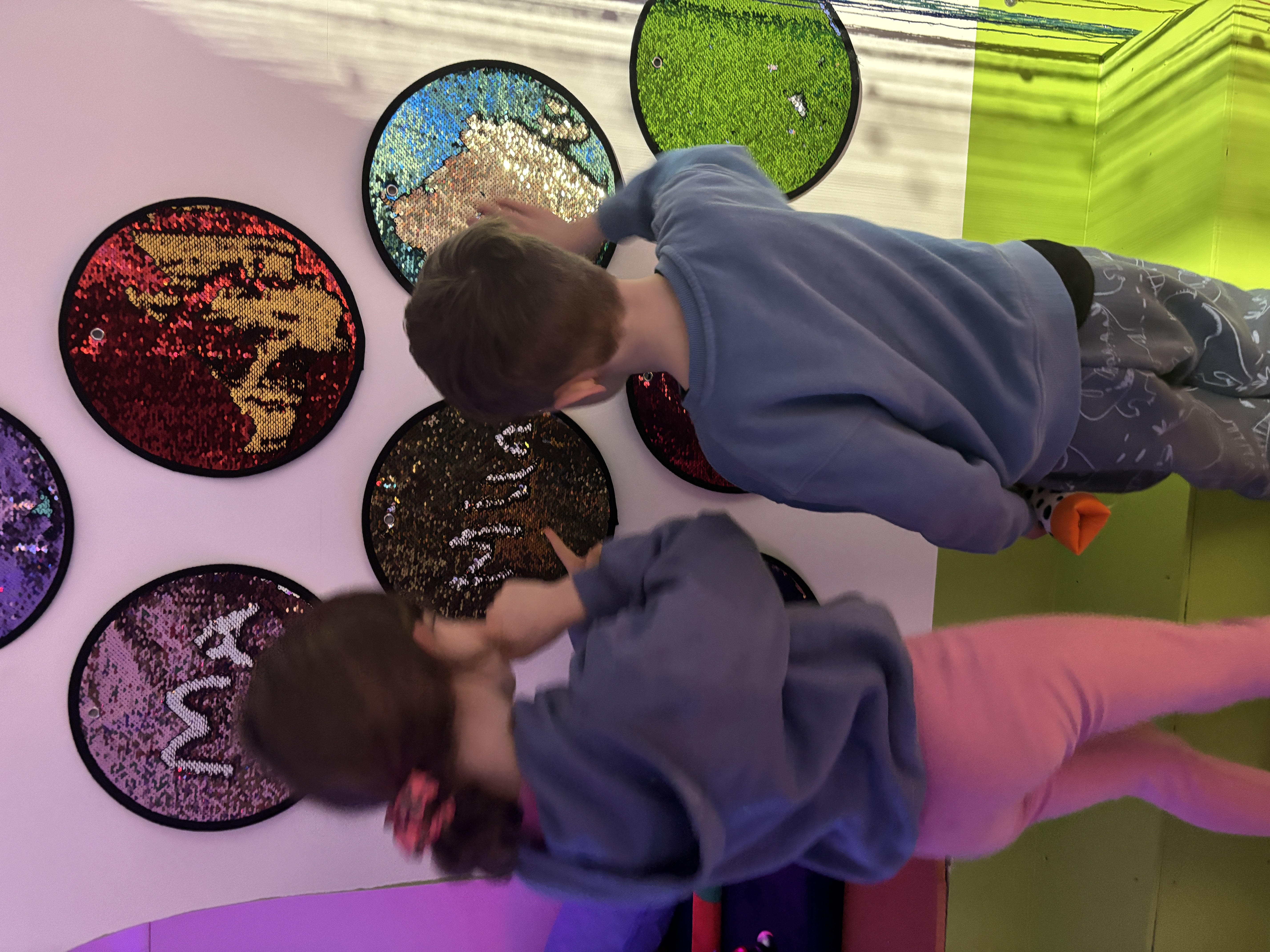 Children interacting with colorful sensory wall panels at The Angel Centre Sensory Gym