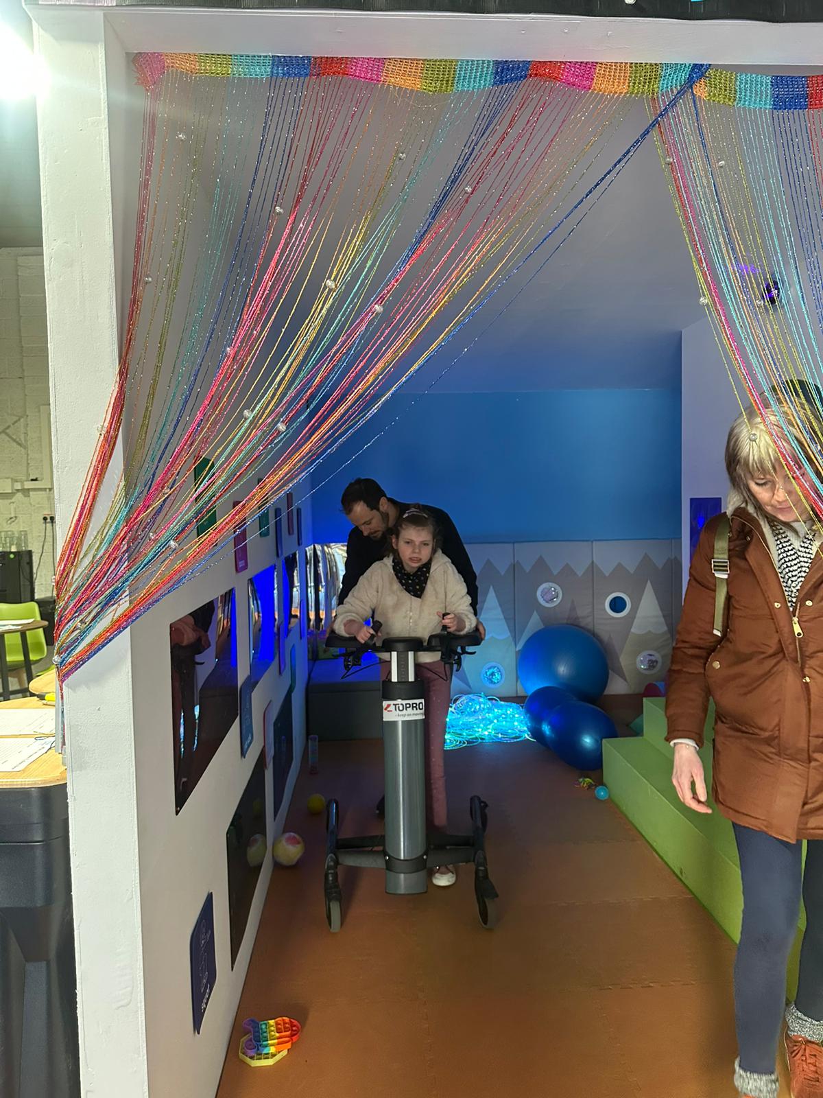 Sensory gym equipment with rainbow curtains and adaptive equipment